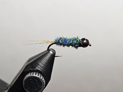 A blue and green iridescent variation of the Maple syrup fly pattern, a New England pond classic invented by Maine angler and tyer Alvin Theriault, tied by New England Fly Company