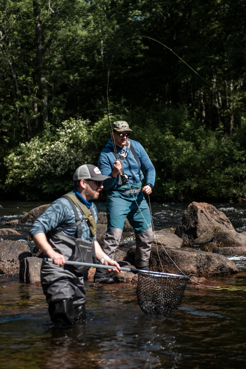 An angler hooks into a native landlocked salmon on a guided fly fishing trip with New England Fly Company.